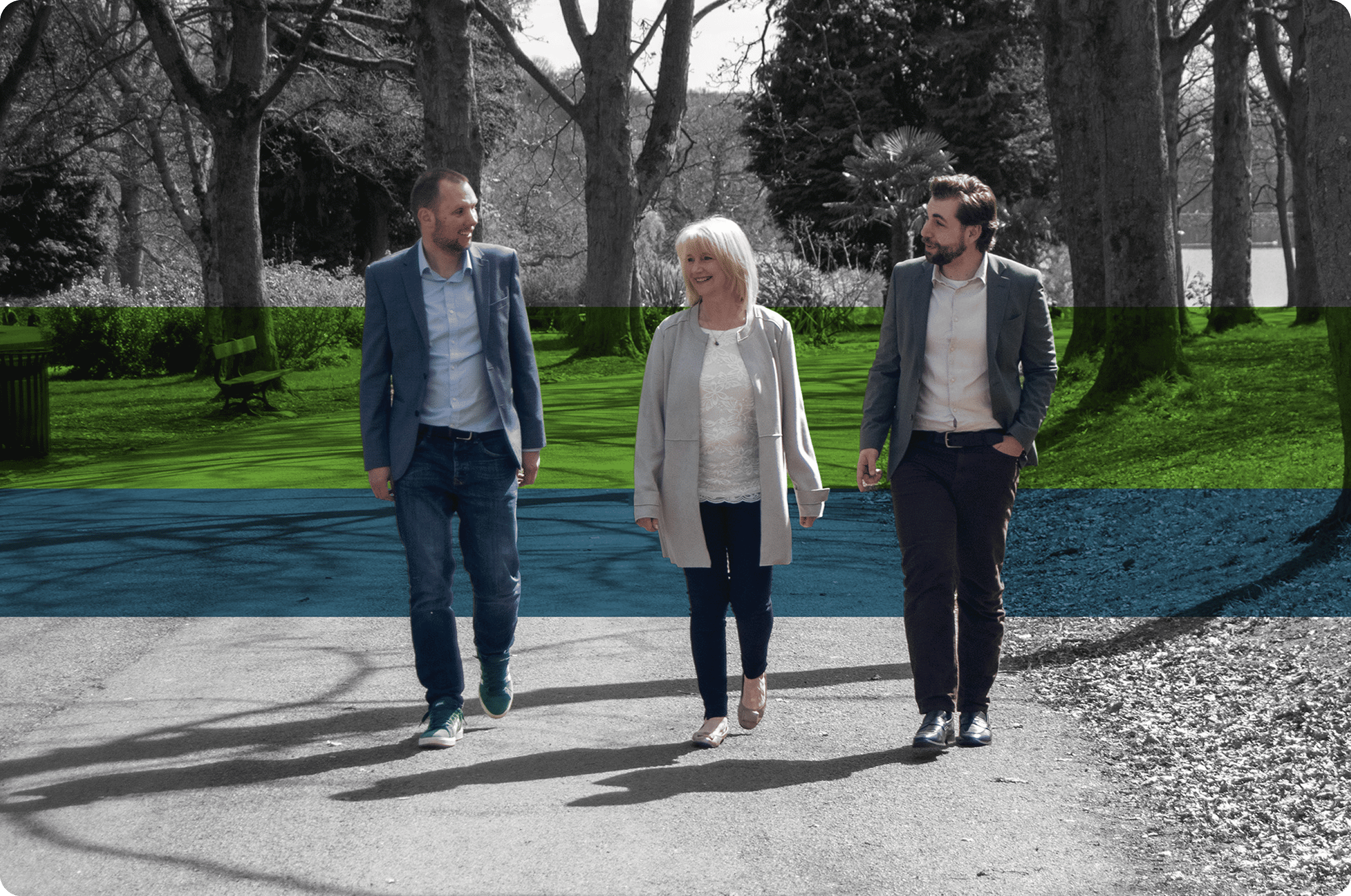 A black and white photo shot in a park showing m-powered founders walking along the path and smiling at each other.